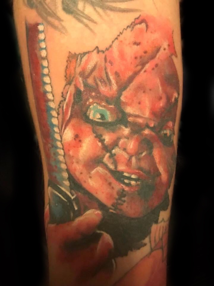Colour Chucky horror portrait with scarred face on forearm by Jin