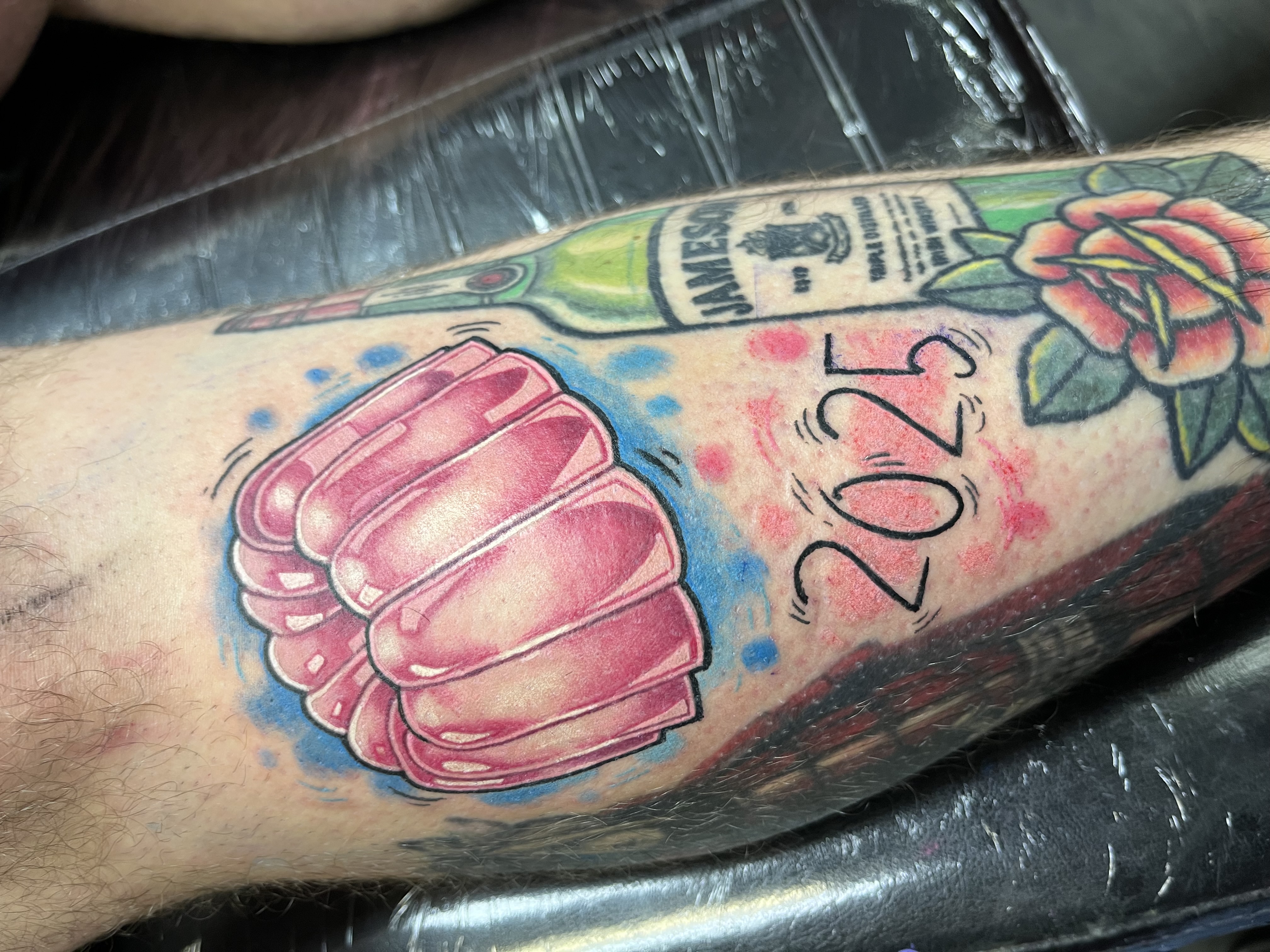 Neo-traditional jelly mould and Jameson whiskey bottle tattoo by Leo