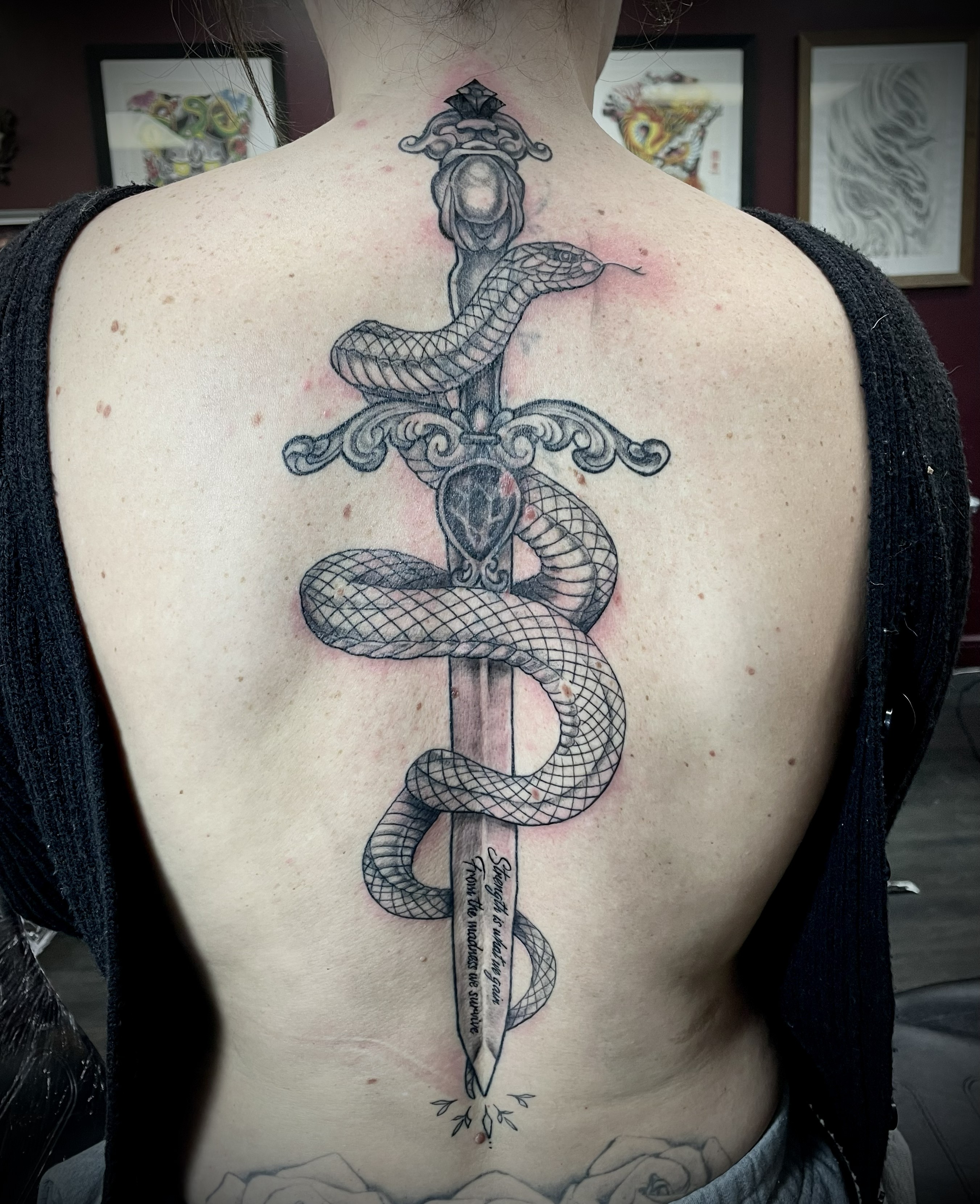 Black and grey ornate dagger with snake and script lettering spine piece by Matt
