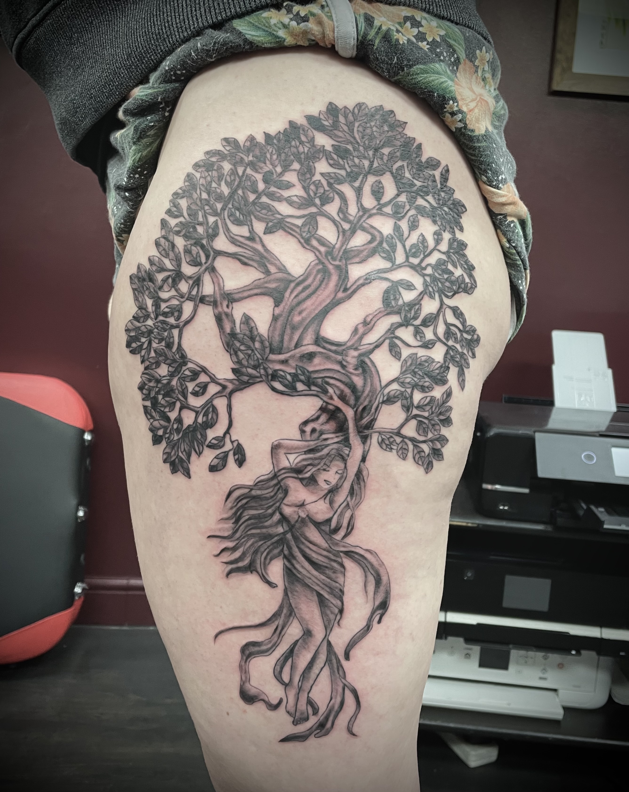 Black and grey tree of life with woman figure emerging from trunk thigh piece by Matt