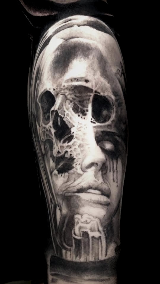 Black and grey skull and female face morph tattoo by Ray
