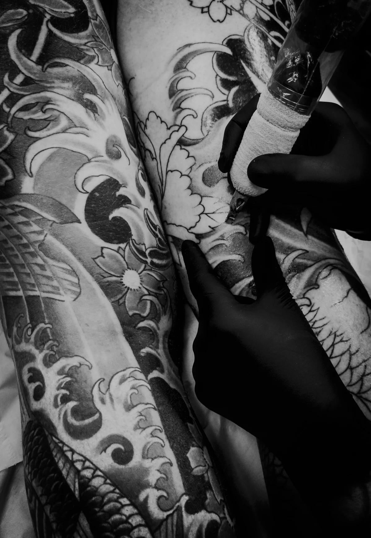 Professional tattoo artist working on intricate tattoo design in modern studio